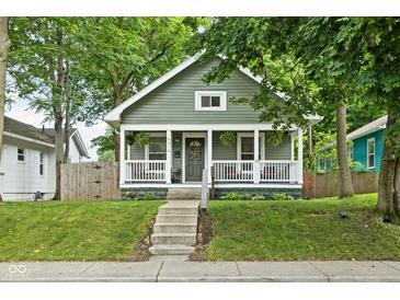 Charming home featuring a cozy front porch, inviting curb appeal, and lovely landscaping at 4414 Winthrop Ave, Indianapolis, IN 46205