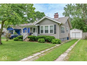 Charming home featuring a well-maintained lawn, manicured hedges, and a cozy front porch at 4922 Brookville Rd, Indianapolis, IN 46201
