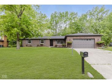Brick home with a well-manicured lawn, mature trees, and an attached two-car garage at 5982 Melbourne Rd, Indianapolis, IN 46228