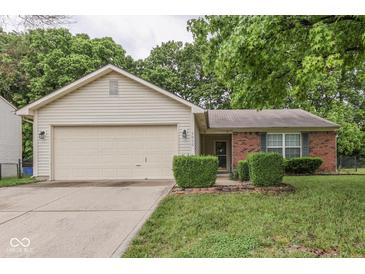 Charming single-story home featuring a garage and a combination of brick and light siding at 6010 Rocky River Dr, Indianapolis, IN 46221