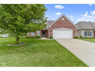 Well-maintained brick home with a manicured lawn, mature tree, and attached two-car garage at 7128 Willow Pond Dr, Noblesville, IN 46062