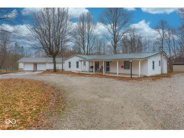 Charming single-story home with a covered porch, gravel driveway, and ample parking at 8230 W Pocket Hollow Rd, Gosport, IN 47433