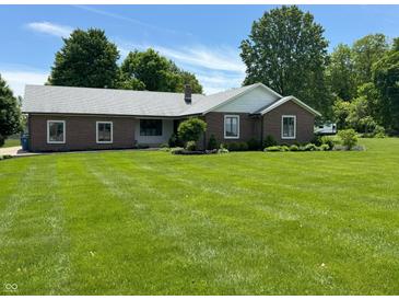 Charming brick ranch-style home with lush green lawn and mature trees at 8711 E 296Th St, Atlanta, IN 46031