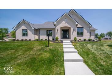 Beautifully landscaped, single-story white brick home featuring a manicured lawn at 10586 Jacks Way, Indianapolis, IN 46234