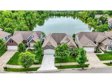 Aerial view of homes surrounding a serene lake, showcasing neighborhood layout and landscaping at 1071 Serenity Ct, Carmel, IN 46280
