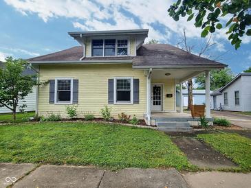 Charming home featuring a well-maintained lawn, inviting porch, and beautiful landscaping at 1336 Lafayette Ave, Columbus, IN 47201