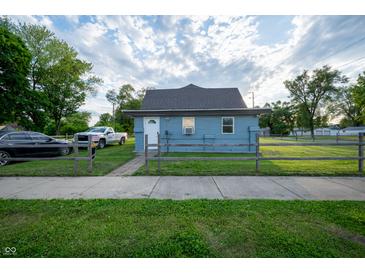 Charming exterior of a light blue home with well-maintained lawn and picket fence at 2358 Hovey St, Indianapolis, IN 46218