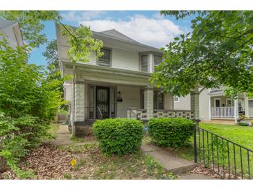 Charming two-story home featuring a cozy front porch and well-maintained landscaping in a residential neighborhood at 2823 Boulevard Pl, Indianapolis, IN 46208