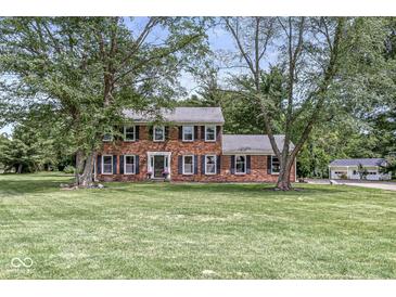 Charming two-story brick home featuring a well-maintained lawn and mature trees, offering classic curb appeal at 3030 E 236Th St, Cicero, IN 46034