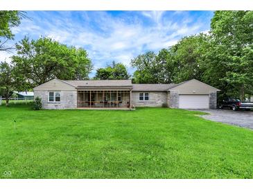 Charming single-story home featuring stone facade and attached garage, complemented by a spacious green lawn at 4125 S Post Rd, Indianapolis, IN 46239