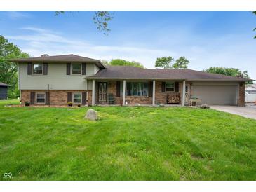 Charming two-story home features a welcoming front porch and an attached two car garage at 5631 N Olivia Dr, Alexandria, IN 46001