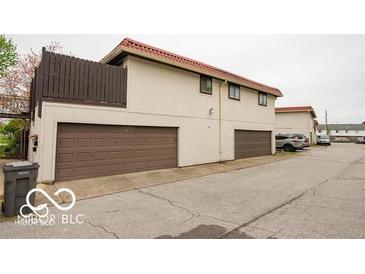 Two-story condo featuring a red tile roof and convenient garage parking at 8361 Paso Del Norte Ct, Indianapolis, IN 46227