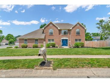 Charming two-story brick home with a well-manicured lawn and a bright blue front door at 9754 Bradford Knoll Dr, Fishers, IN 46037
