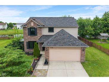 Two-story home with brick and vinyl siding, complemented by a well-manicured lawn and an attached two-car garage at 1408 Snead Cir, Avon, IN 46123