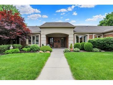 Inviting brick home with well-manicured landscaping, covered entrance, and charming curb appeal at 423 Bent Tree Ln, Indianapolis, IN 46260