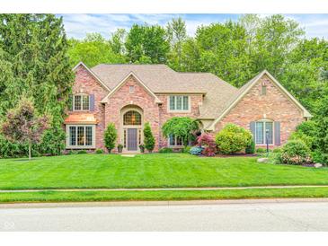 Charming brick home featuring a manicured lawn and mature trees, perfect for curb appeal at 5404 Cayman Dr, Carmel, IN 46033