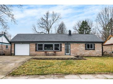 Charming single-story home with a brick facade, attached garage, and cozy front porch area at 634 Park Dr, Greenwood, IN 46143