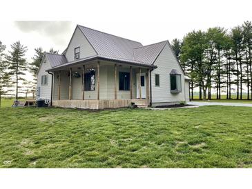 Charming two-story home featuring a metal roof, inviting porch, and a well-manicured front yard at 6593 N 800 W, Elwood, IN 46036