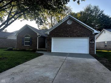 Charming brick home with a two-car garage, mature trees, and a well-maintained lawn at 6845 Arjay Dr, Indianapolis, IN 46217