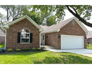 Charming brick home featuring an attached two car garage, well manicured lawn, and attractive landscaping at 6845 Arjay Dr, Indianapolis, IN 46217
