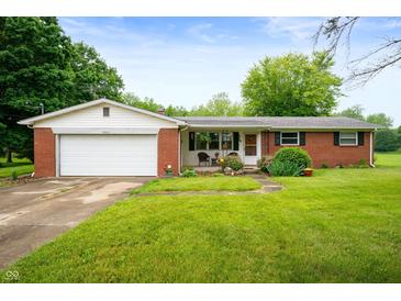Charming brick ranch-style home featuring a well-manicured lawn, attached garage, and cozy front porch at 8027 S 250 E, Markleville, IN 46056