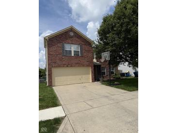 Two-story brick home with a two-car garage and a basketball hoop in the driveway at 10194 Lothbury Cir, Fishers, IN 46037