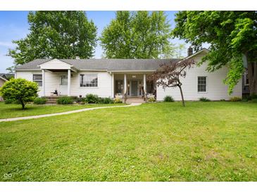 Charming single-story home with a well-manicured lawn and inviting walkway at 1212 Woodlawn Ave, Indianapolis, IN 46203