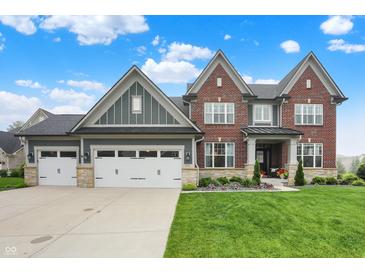 Beautiful two-story brick home featuring a three-car garage and well-manicured lawn at 15023 Glenmoor Cir, Carmel, IN 46033