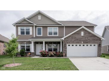 Charming two-story home with brown siding, brick accents, white trim, and an attached two-car garage at 1661 Devonshire Ave, Avon, IN 46123