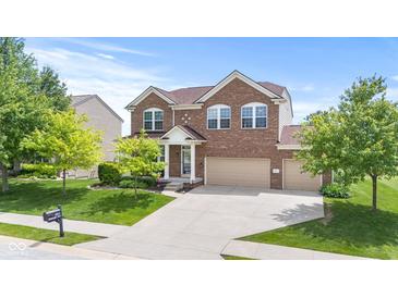 Two-story brick home with a well-manicured lawn and attached two-car garage under a blue sky at 1821 Midnight Pass, Brownsburg, IN 46112