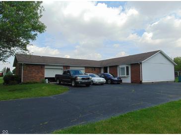 View of the exterior showing the brick and siding, driveway and multiple cars parked at 2625 S 200 E, Lebanon, IN 46052