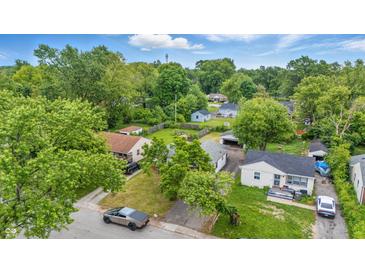 Expansive aerial view of a neighborhood with mature trees and well-maintained homes on a sunny day at 3615 N Dequincy St, Indianapolis, IN 46218