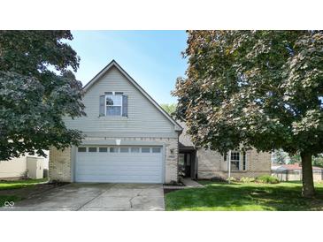 Charming two-story home with brick accents, a two-car garage, and a well-maintained front yard with mature trees at 3959 Towhees Dr, Indianapolis, IN 46237