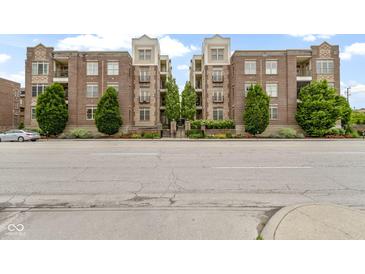 Charming brick condo building with balconies, mature trees, and manicured landscaping at 450 E Ohio St # Apt 305, Indianapolis, IN 46204