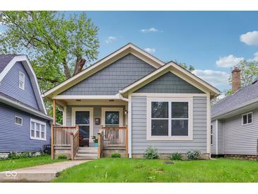 Charming bungalow featuring craftsman architecture, a covered front porch, and a well-maintained lawn at 617 N Dearborn St, Indianapolis, IN 46201