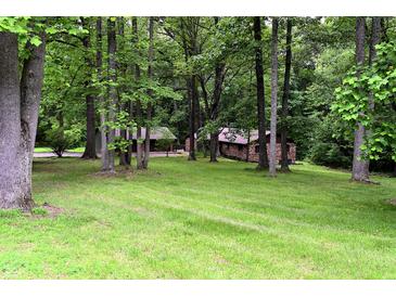 Secluded brick home exterior nestled among mature trees and lush green lawn at 6190 Red Day Rd, Martinsville, IN 46151