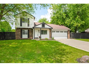 Charming two-story home with a brick and siding exterior, lush green lawn, and attached two car garage at 8416 Buckingham Dr, Columbus, IN 47201