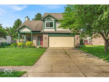 Charming two-story home with a well-manicured lawn and attached two car garage at 8908 Sunningdale Blvd, Indianapolis, IN 46234
