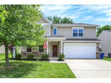 Charming two-story home featuring a well-maintained lawn, an attached garage, and tasteful landscaping at 11437 High Grass Dr, Indianapolis, IN 46235