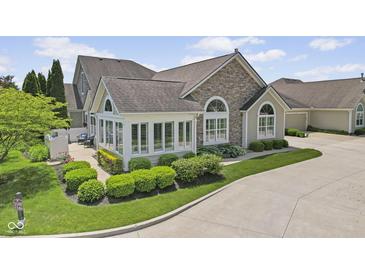Beautiful home exterior boasts stone accents, manicured landscaping, and ample natural light at 1146 Distinctive Way, Greenfield, IN 46140