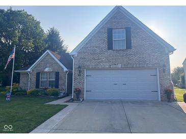 Charming brick home with a two-car garage, well-manicured lawn and patriotic American flag at 2018 Alysheba Dr, Indianapolis, IN 46234