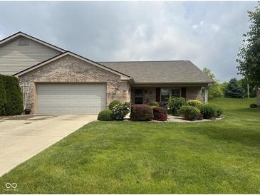 Well-maintained brick home featuring an attached garage and a beautifully landscaped front yard at 2916 Wind Chime Cir, Greenwood, IN 46143