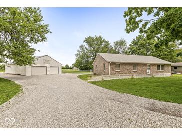 Charming brick home with a gravel driveway and a large outbuilding, perfect for a workshop or storage at 312 W Clark Ln, Fairland, IN 46126
