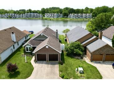 Aerial view of brick home with an attached two car garage and waterfront views at 3404 Maritime Dr, Indianapolis, IN 46214