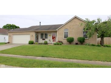 Charming brick home with a well-maintained lawn, attached garage and a red front door at 3645 Richland Dr, Columbus, IN 47203