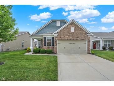 Charming brick home featuring a two-car garage and well-maintained lawn at 5125 Lilium Dr, Plainfield, IN 46168