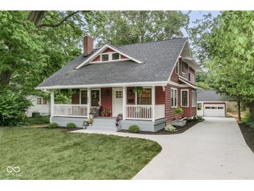 Charming home featuring a classic red exterior, inviting front porch, and well-maintained landscaping at 625 E 57Th St, Indianapolis, IN 46220