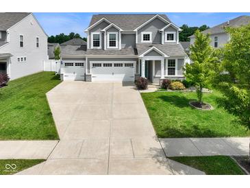 Charming two-story home with a three-car garage, manicured lawn, beautiful landscaping, and attractive curb appeal at 6830 Park Grove Blvd, Whitestown, IN 46075