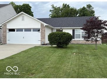 Charming home featuring a two-car garage, well-kept lawn, and inviting curb appeal at 7022 Cordova Dr, Indianapolis, IN 46221