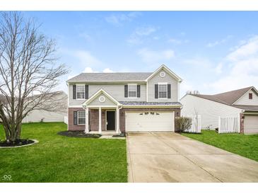 Charming two-story home with gray siding, brick accents, and a well-maintained lawn at 9220 Crossing Dr, Fishers, IN 46037